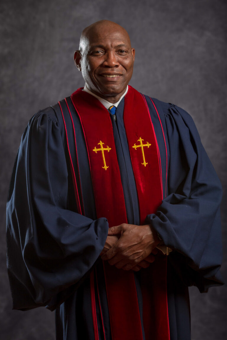Black male minister dressed in clergy robe.