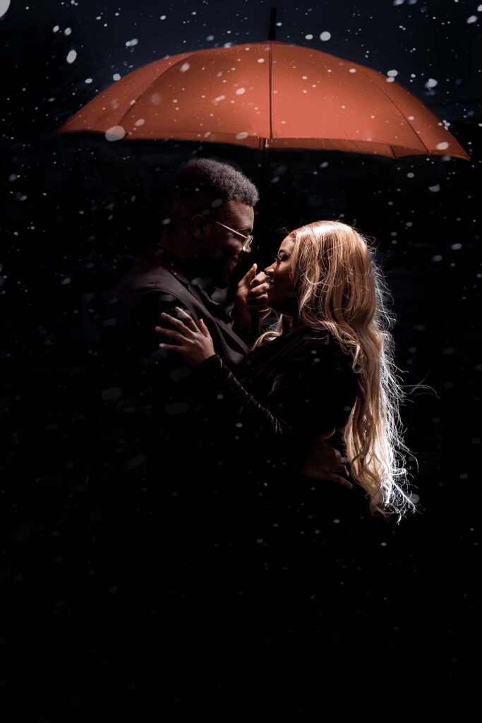 African American couple in the snow with red umbrella