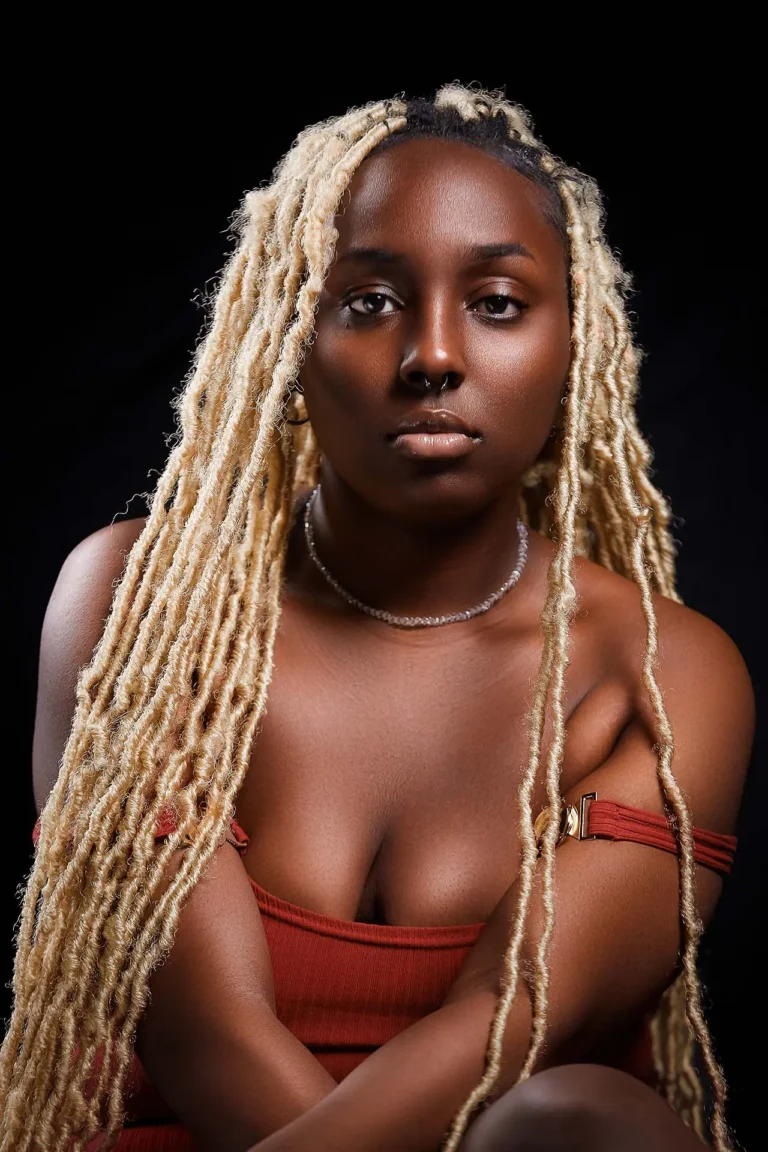 Beautiful black female with long white locks, sexy red thin strapped dress.