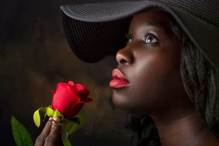 Beautiful black woman with red rose and black hat.